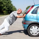 Homem empurrando um carro