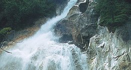 Riacho de montanha de fluxo rápido e queda alta